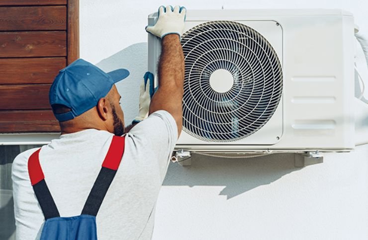 A technician works on an air conditioner, highlighting appliance repair services in Renton, WA.
